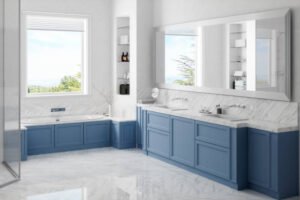 A bathroom in Long Beach, CA, featuring blue cabinets and a spacious bathtub, creating a serene and stylish atmosphere, perfect for bathroom remodeling.