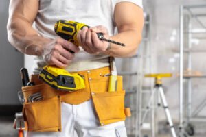 Handyman service in Newport Beach CA – a man wearing a hard hat holding a tool on a construction site.