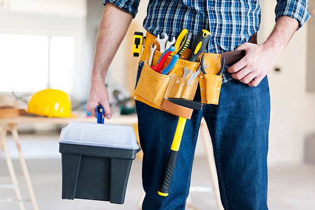 Handyman in Huntington Beach, CA, holding a tool belt and toolbox, ready for a construction or repair task