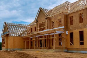 A house under construction in Long Beach, featuring exposed wooden framing and scaffolding, highlighting affordable handyman services.