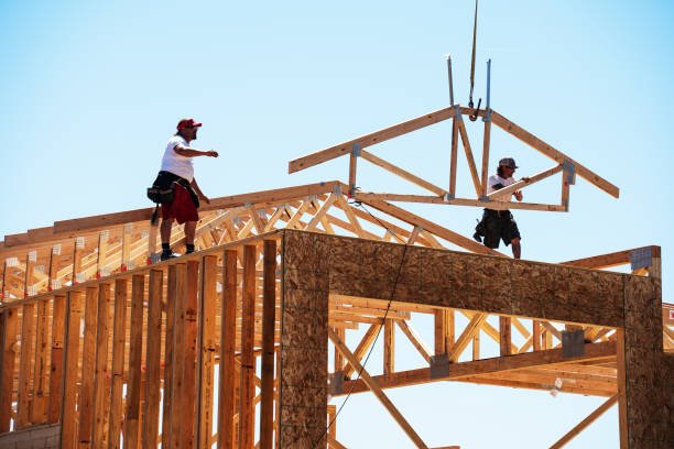Two skilled professionals providing affordable handyman services in Long Beach, working on carpentry and framing at a home construction site.